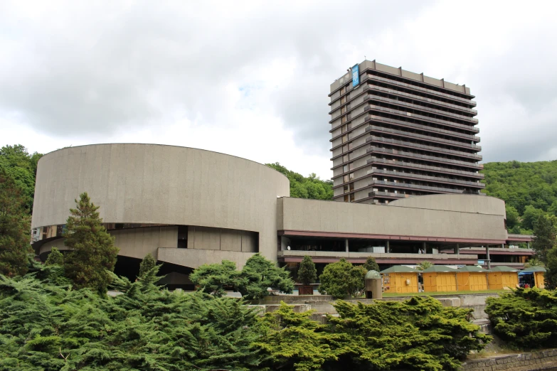 an empty building surrounded by trees on a cloudy day