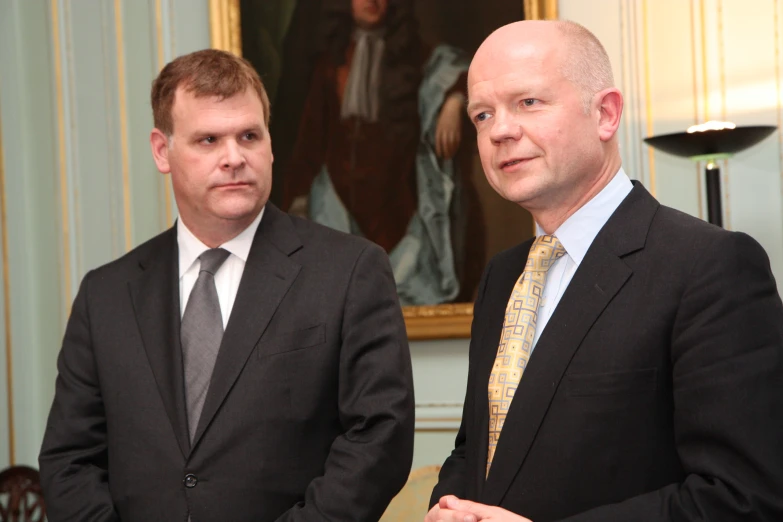 two men with suits and ties posing for the camera