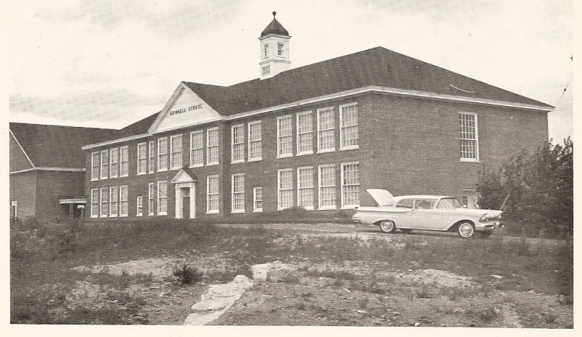 an old picture shows the building with cars parked in front