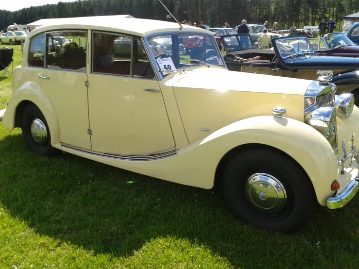 this old car is parked in the grass