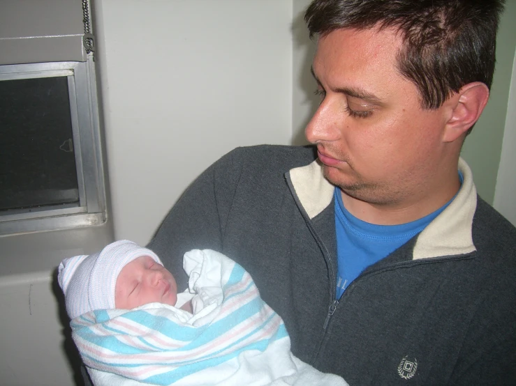 a man holding a baby in a hospital room