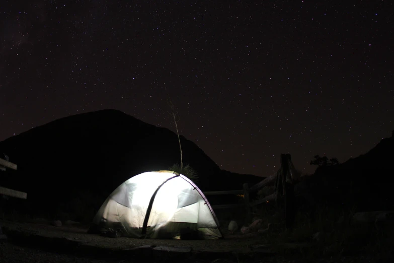 the stars shine brightly in the night sky over a tent