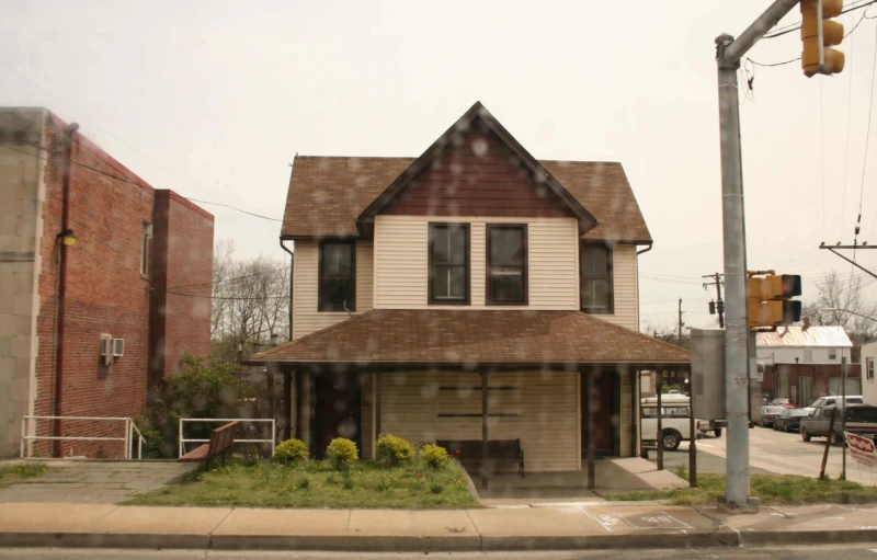 a street corner with a brown and white house