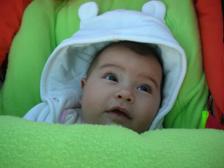 a baby with a cute face in a baby seat