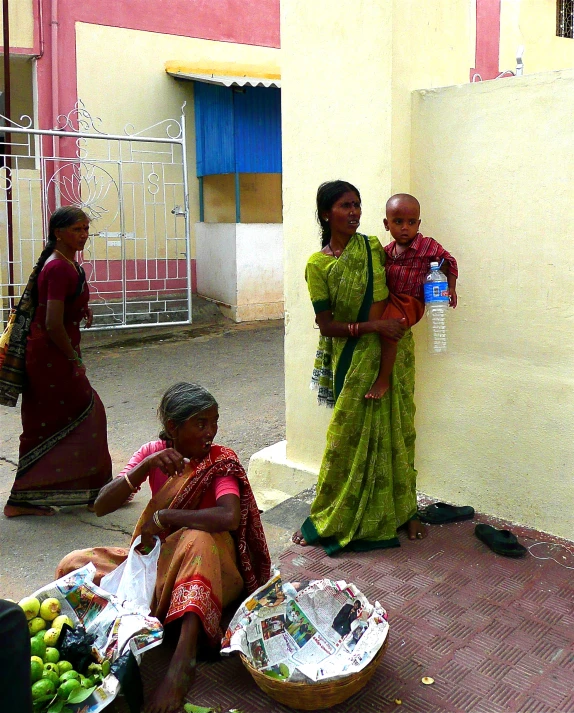 women in different colored saris on the side of a road