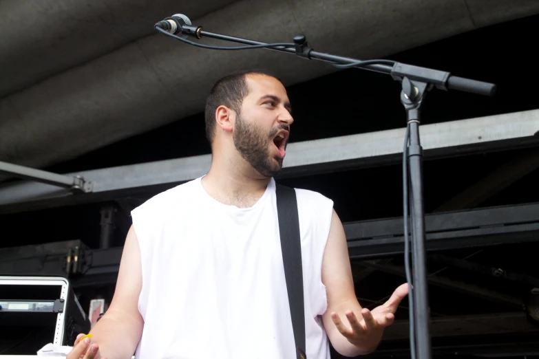 a man with a neck tie standing in front of a microphone