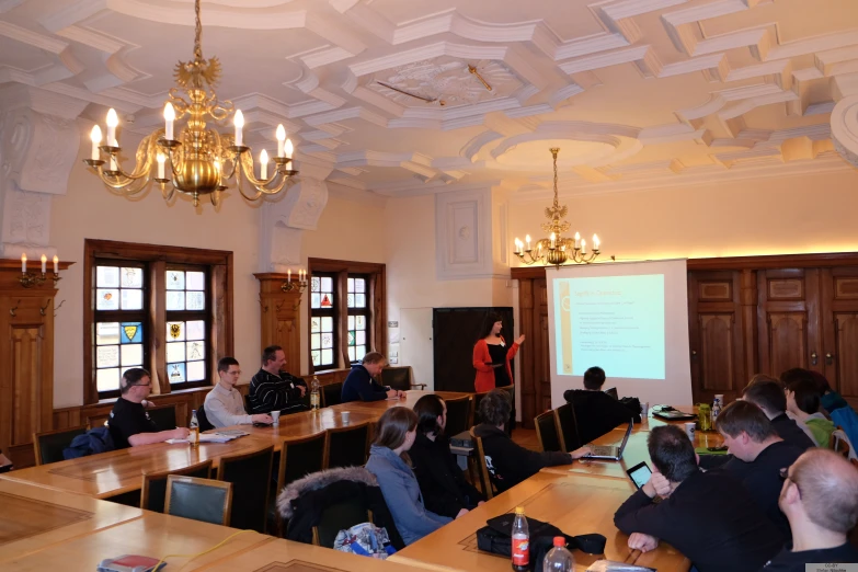 a lecture room full of people sitting at the long desks