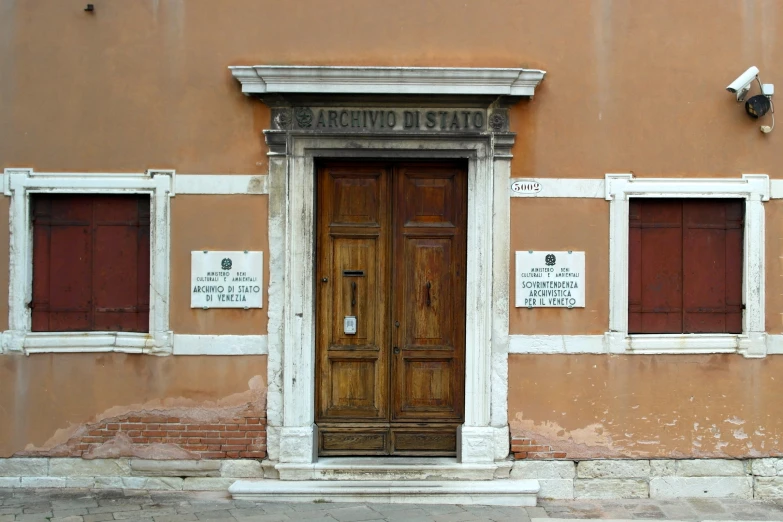 a brown door to an old building that is partially painted red