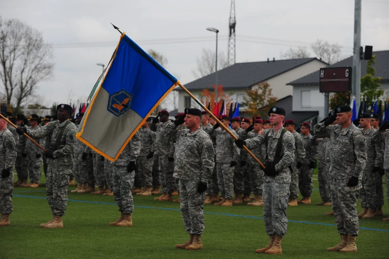 many military men standing around with the colors of the navy