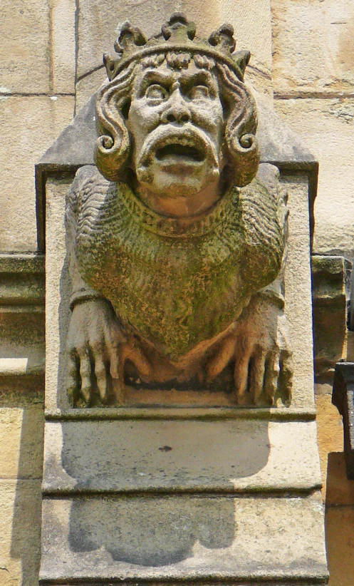 a statue of a man sitting on a ledge