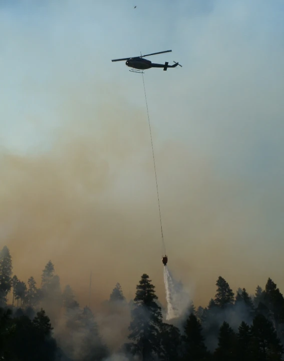 the helicopter is dropping water from a fire