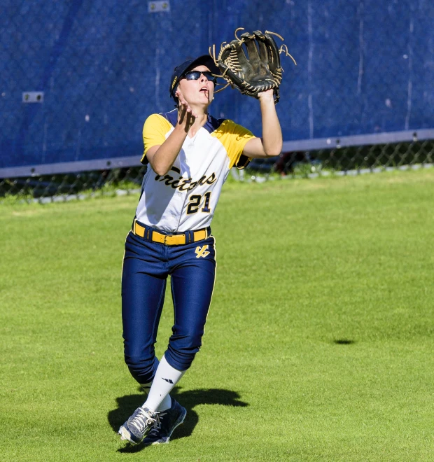 a woman catching a baseball in the air