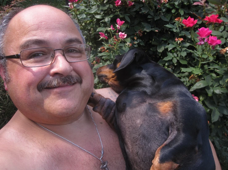 a man with a moustache has his arm around a dog