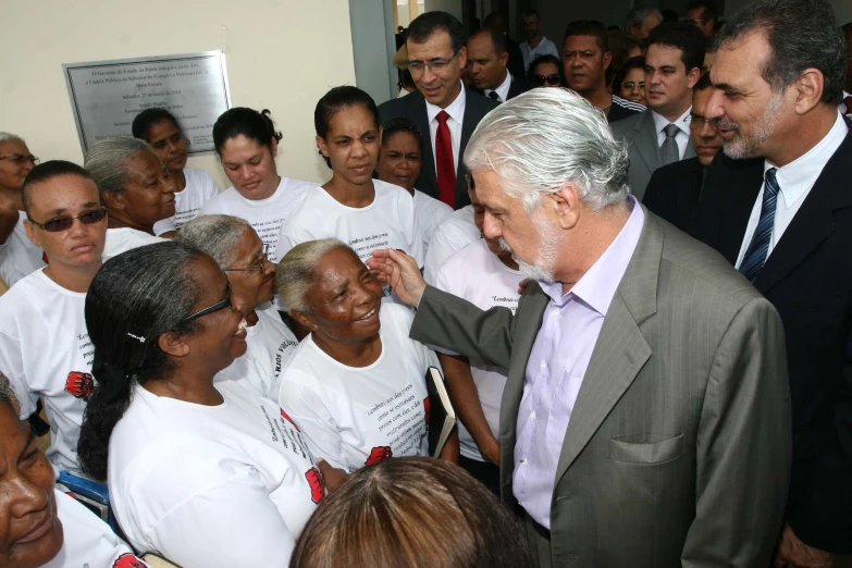 a man standing with a group of people in white t shirts