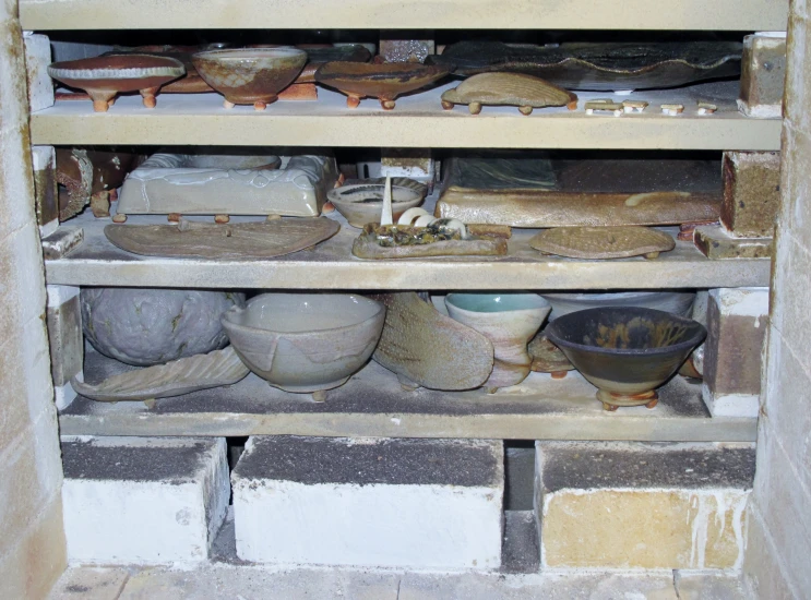 this is a shelf filled with pots and plates