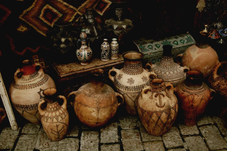 vases are arranged and lined up outside in front of a bench