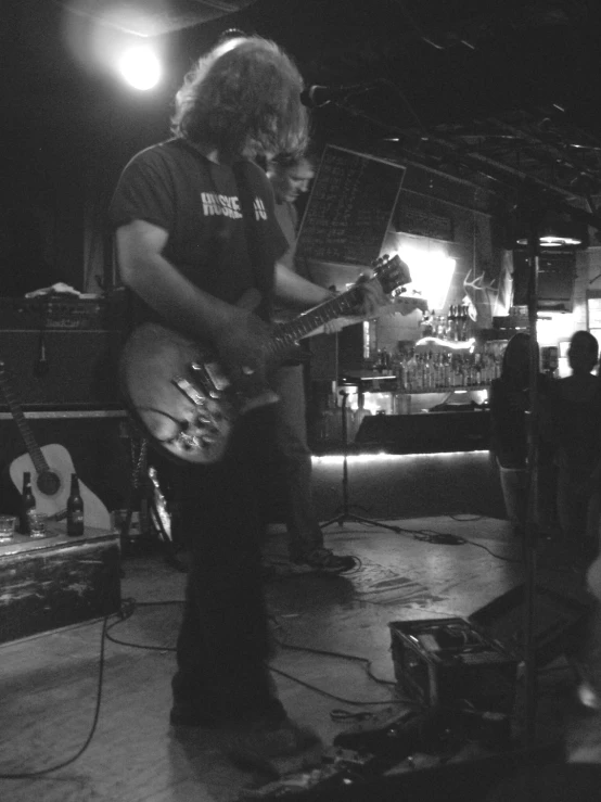 man playing guitar while people watch