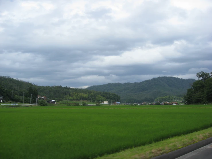 green fields and mountains next to a freeway