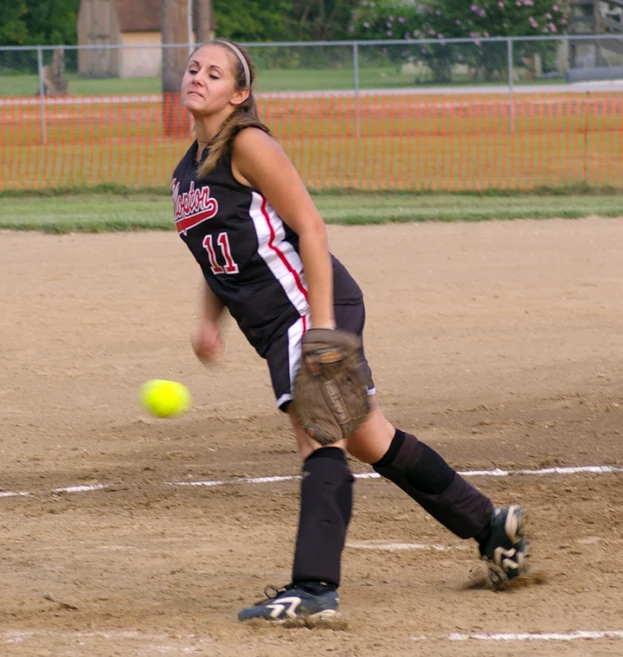 a girl with a catchers mitt in the dirt