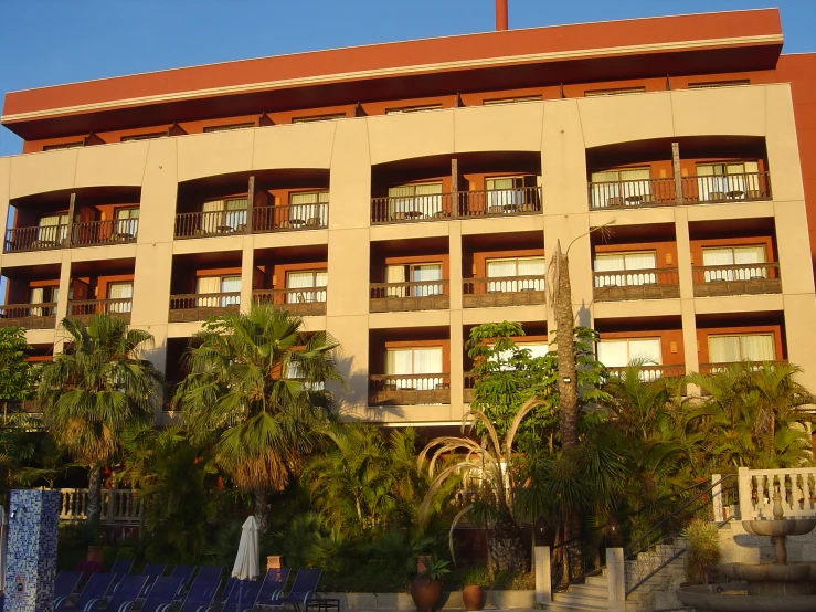 a building is pictured with palm trees and stairs