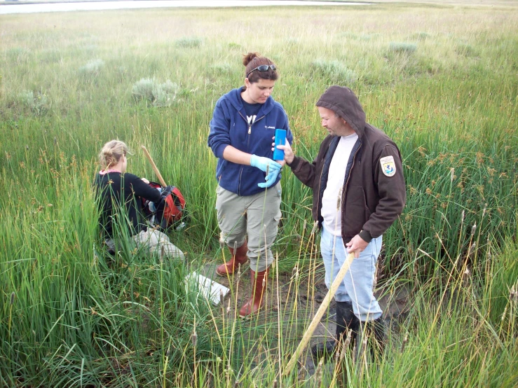 two women are collecting trash in a field