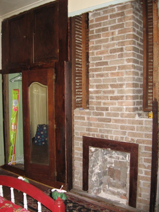 a room with brick fireplace and old wooden doors