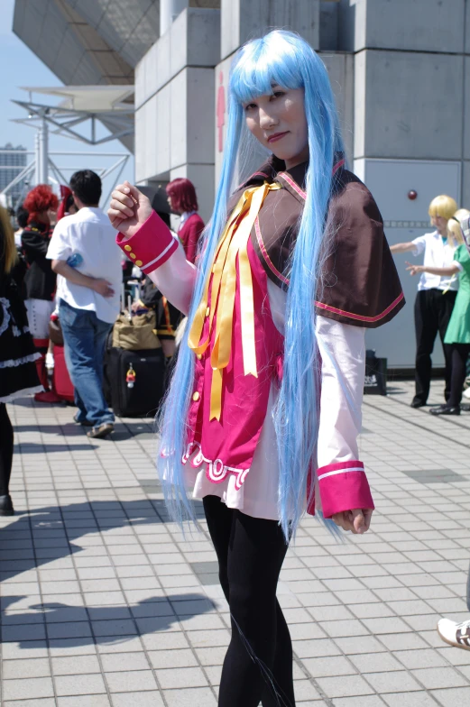 a woman with blue hair in costume poses for a po