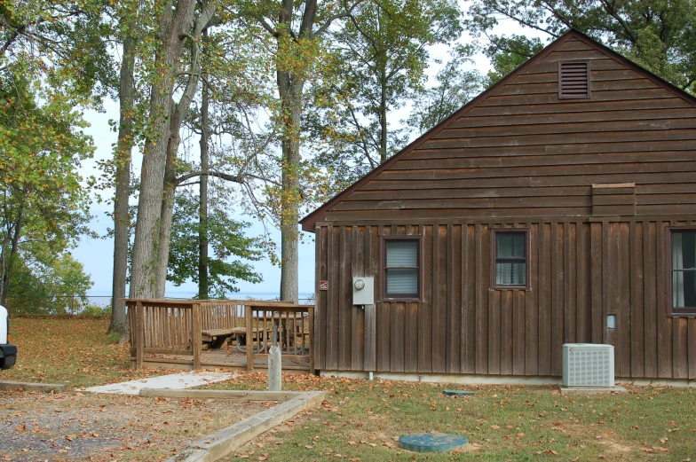 this house has a small shed on the lawn with a grill