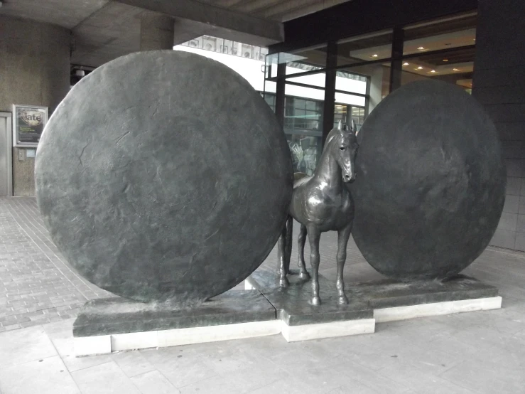 two large round, black, and white sculptures are in front of a building