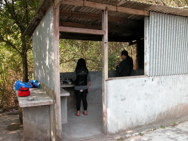 two people in the shade under the shelter