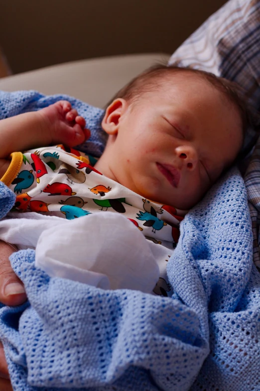 a newborn baby sleeping on top of a blanket