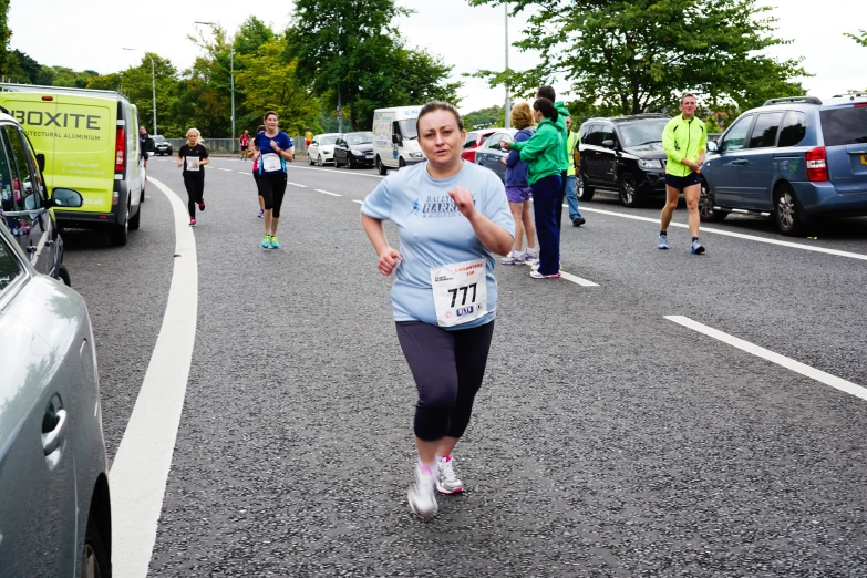 people in a marathon race running on asphalt