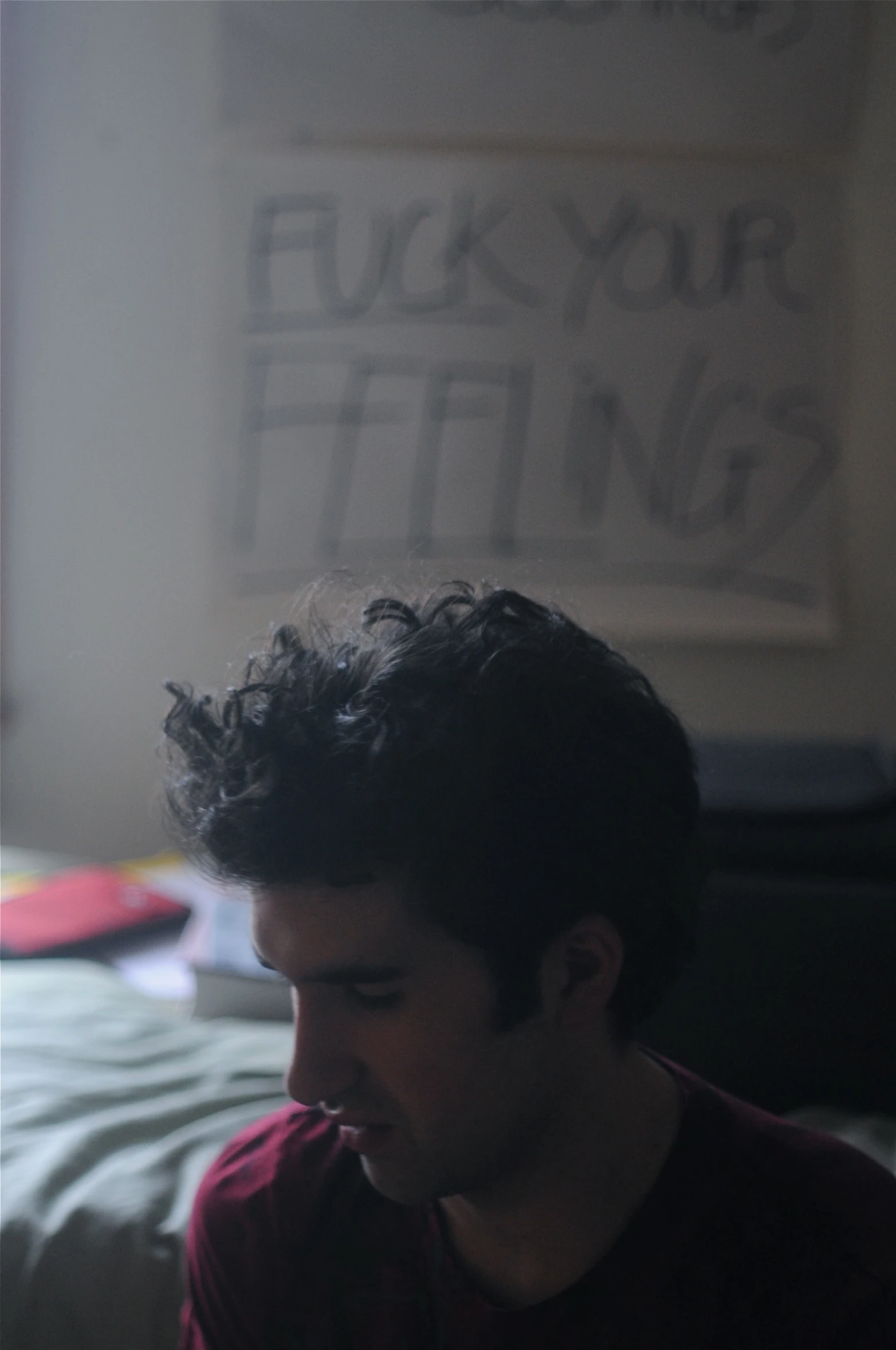 man with curly hair using phone in bedroom