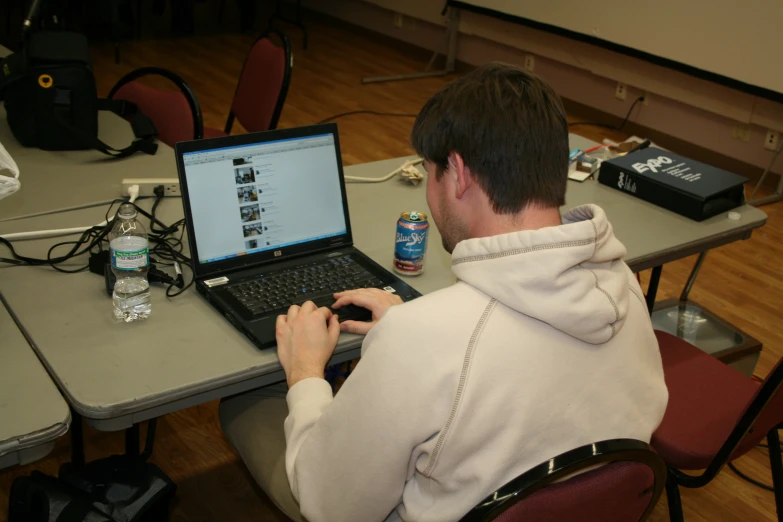 man in white jacket working on computer at table