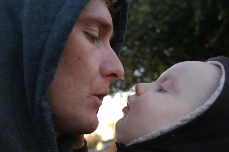 a man holding his baby in front of him