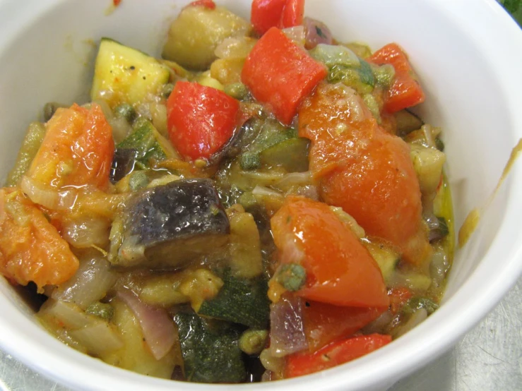 a white bowl filled with vegetables including peppers