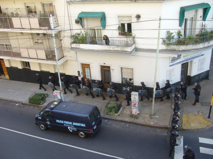 a group of people walking along side of a building