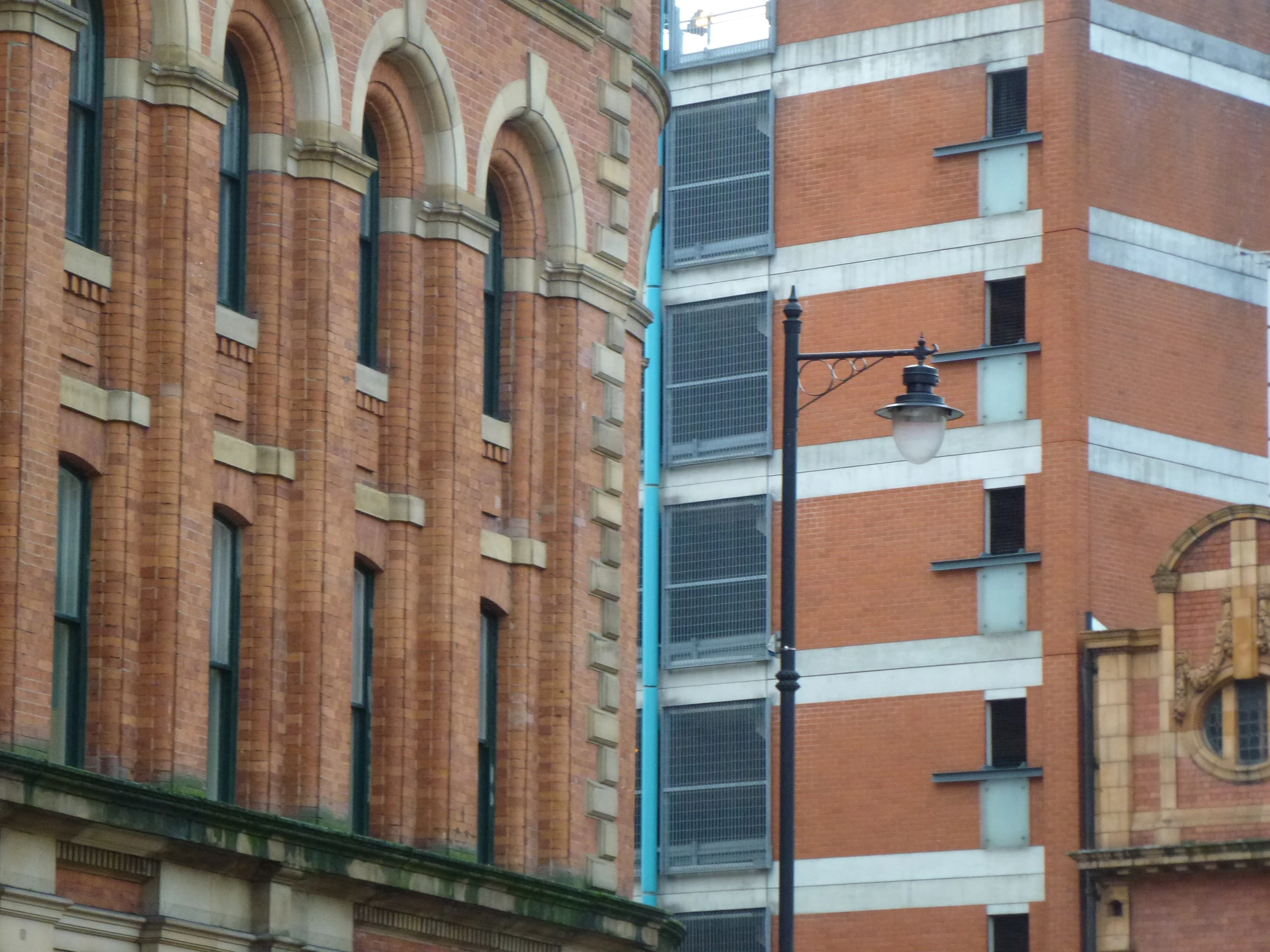 a person on a tower of a building with an outdoor clock and lights