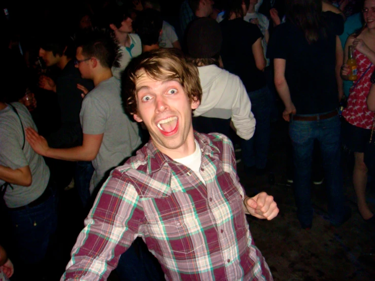 a young man making a goofy face on the dance floor