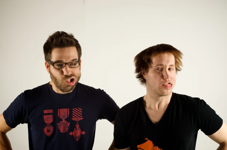 two men with their mouths open while they stand in front of a white background