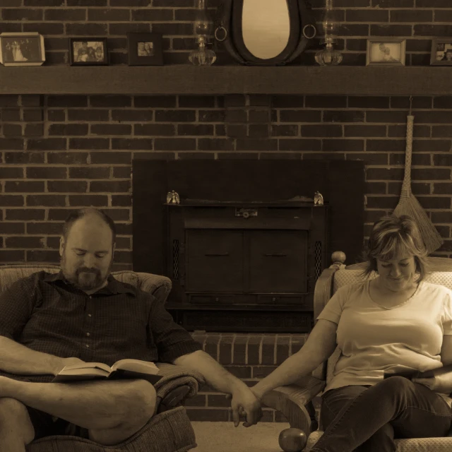 man and woman sitting on a couch, reading