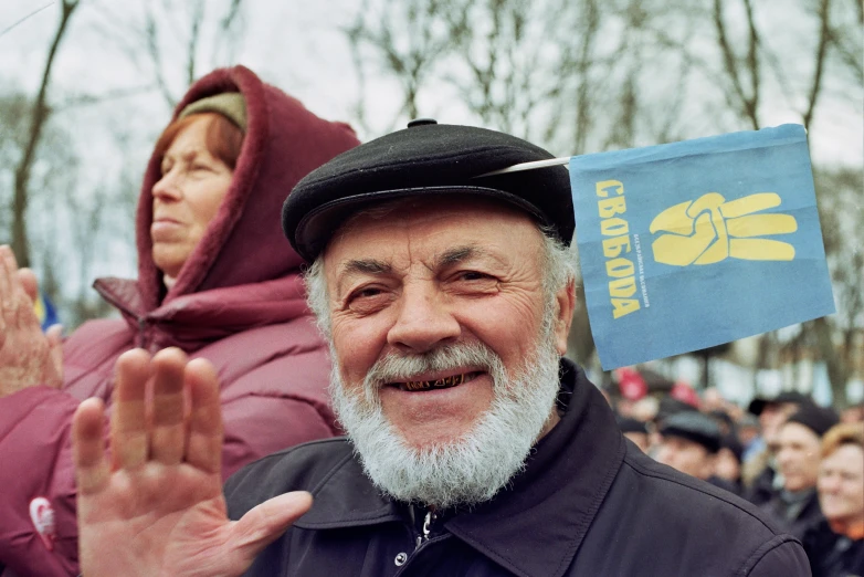 a man in a hat is giving the peace sign