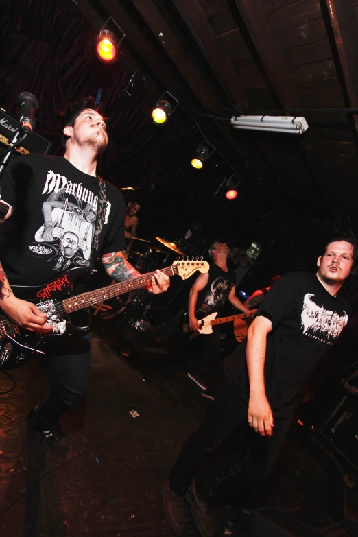 two men are standing in a band playing electric guitars