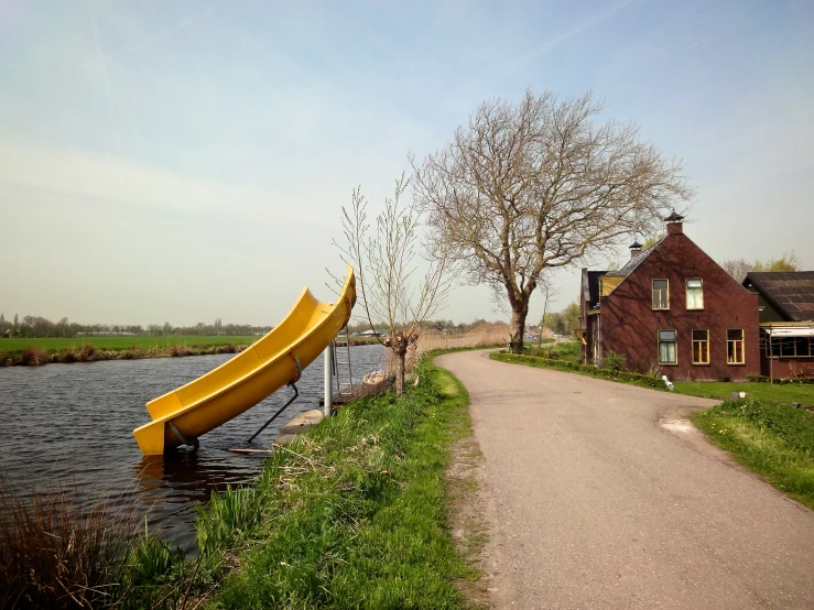a long yellow raft sitting on the edge of a river