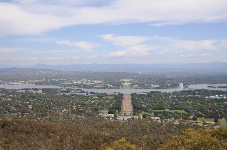 a view of a city surrounded by trees and lakes