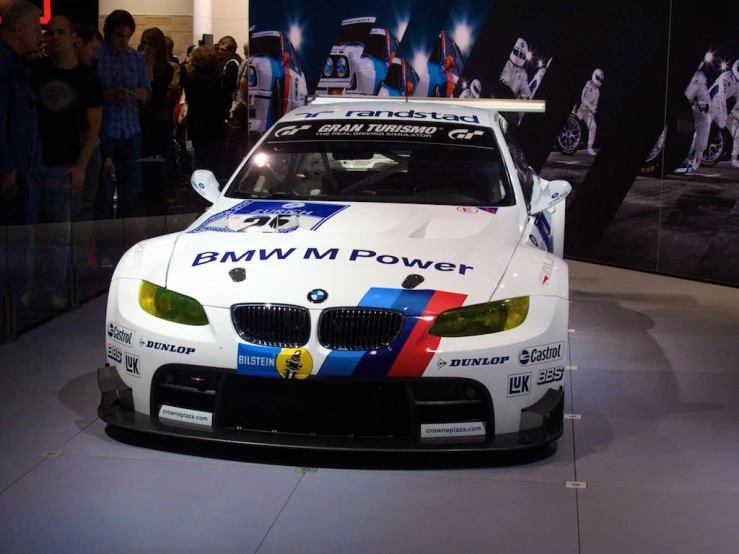 a bmw racing car parked next to each other on a showroom floor