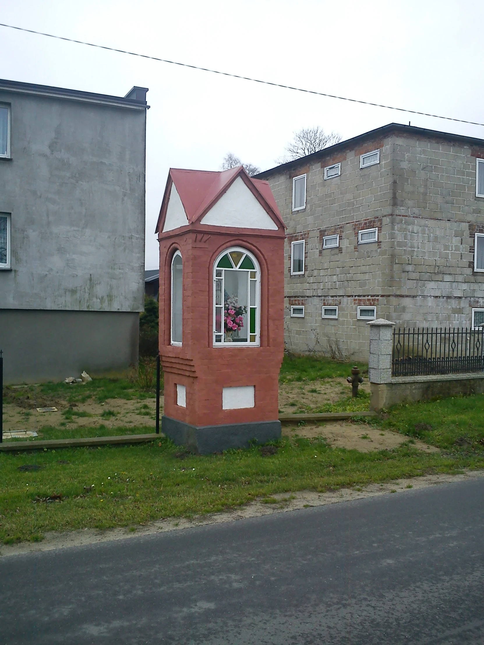 a little red building with a pink and white roof