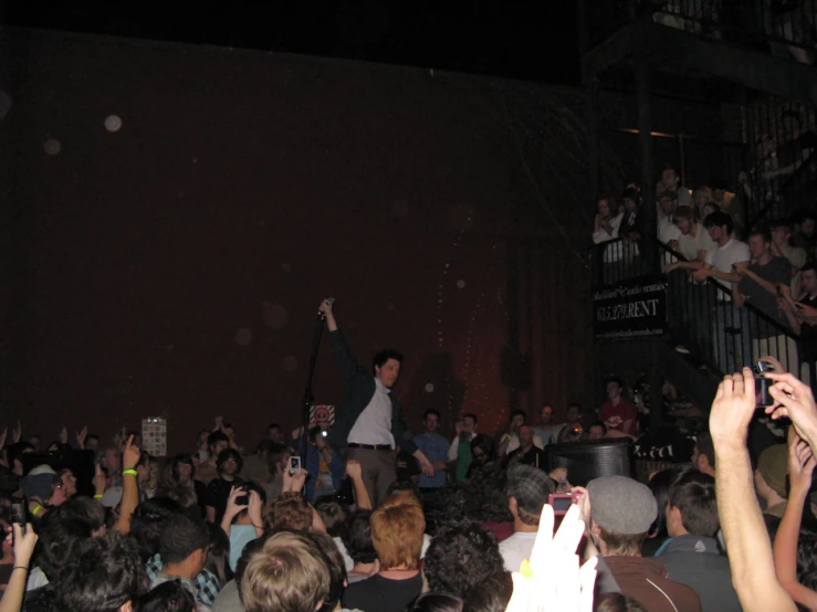 a man is on his cell phone while the audience looks on