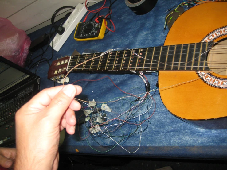 a person holding an acoustic guitar over a table