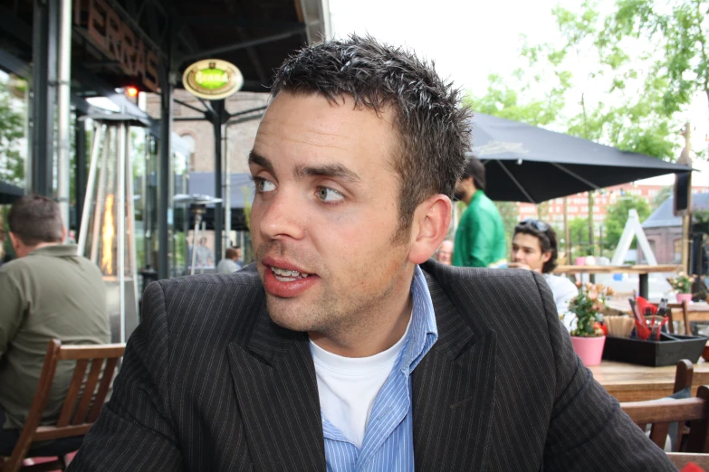 a man wearing a jacket and standing in a restaurant